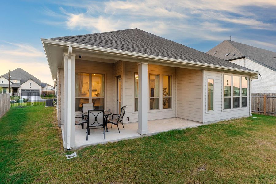 Rear view of property featuring a fenced backyard, a patio, and a shingled roof