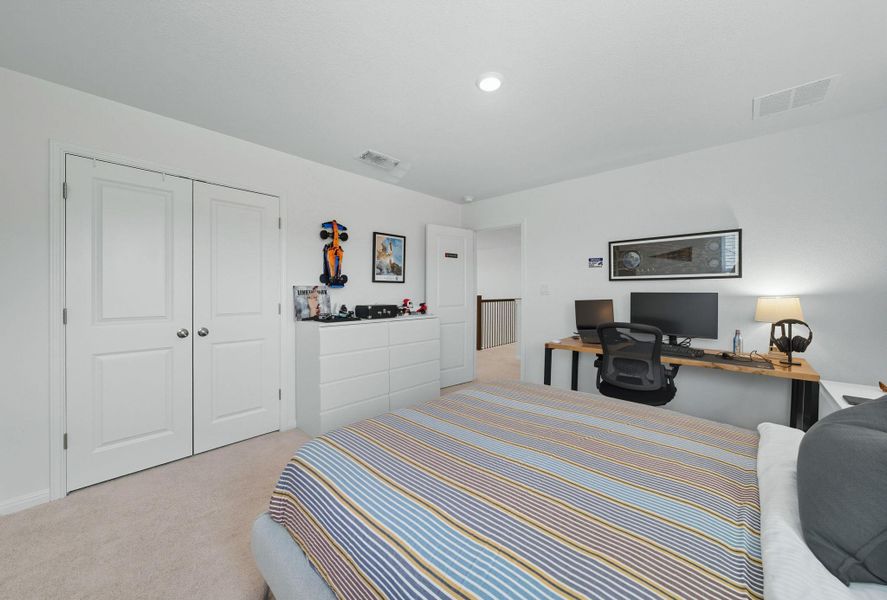 Bedroom with light colored carpet, a closet, and an office area Bedroom with light colored carpet, a closet, and an office area