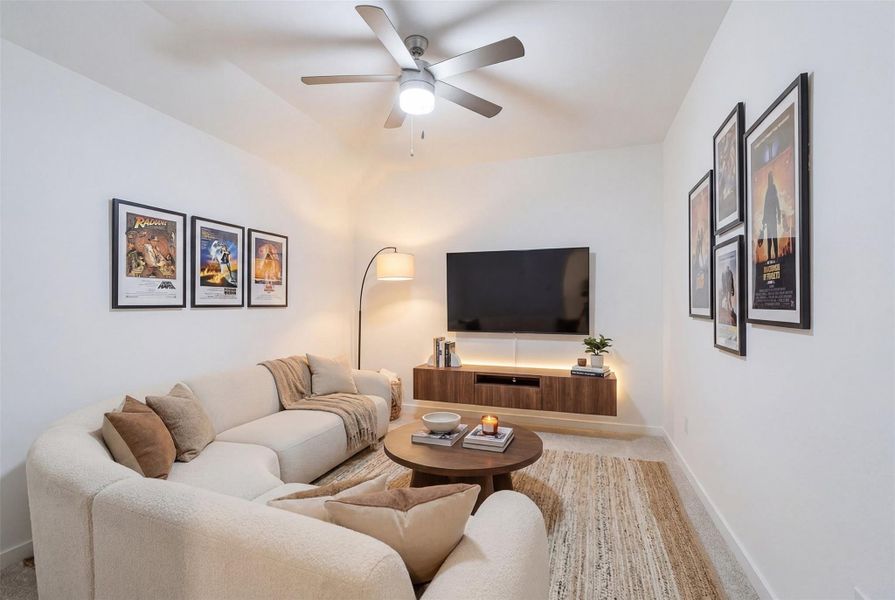 Experience movie nights in style in this luxury media room, featuring custom paint, plush carpet, and a ceiling fan, creating the ultimate cinematic atmosphere right at home. *virtually staged