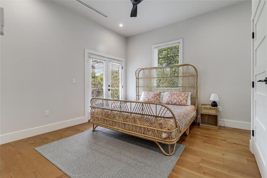 Hardwood floors and a refreshing ceiling fan create an inviting and comfortable sleeping sanctuary.
