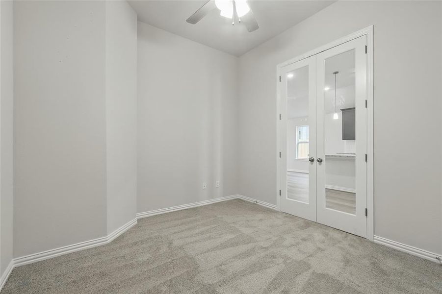 Spare room with ceiling fan, carpet floors, french doors, and baseboards Spare room with ceiling fan, carpet floors, french doors, and baseboards