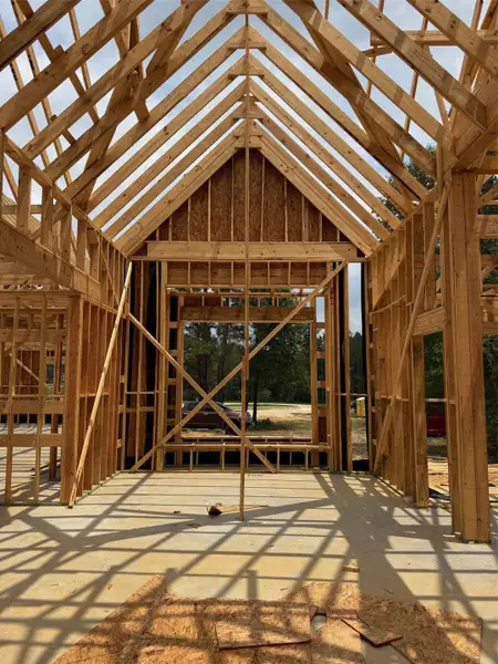 Vaulted ceiling framing featuring exposed wood beams and a large window opening