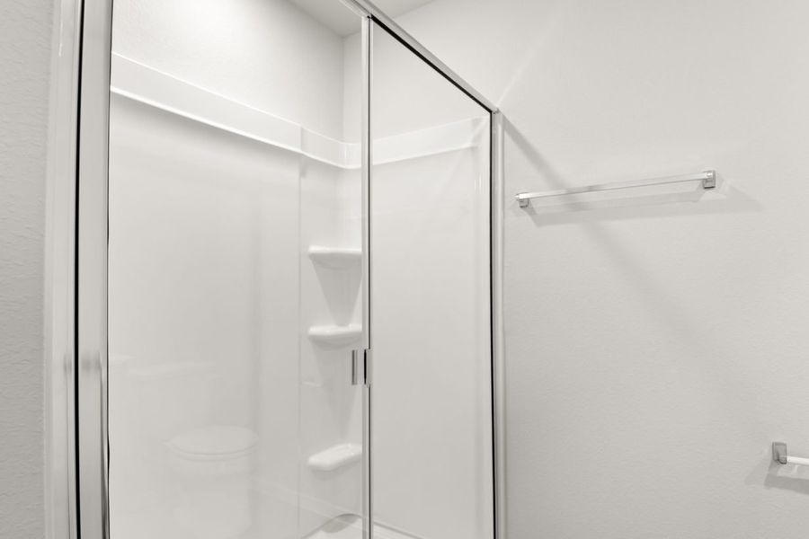 Image of a walk-in shower with white vinyl and a clear pane