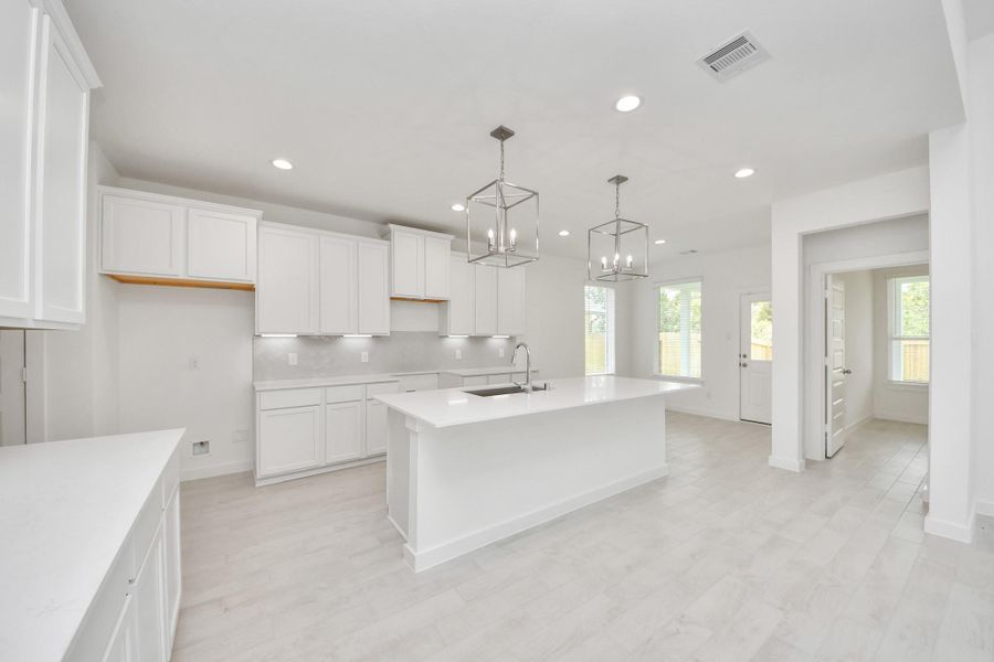 This generously spacious kitchen is a dream realized! With a massive granite island, high ceilings, soft close cabinets, granite countertops, stainless steel appliances, a sleek tile backsplash, recessed lighting, and an extended counter area, it offers both style and practicality. All this opens up to the expansive family room, creating a perfect hub for gatherings. This generously spacious kitchen is a dream realized! With a massive granite island, high ceilings, soft close cabinets, granite countertops, stainless steel appliances, a sleek tile backsplash, recessed lighting, and an extended counter area, it offers both style and practicality. All this opens up to the expansive family room, creating a perfect hub for gatherings.