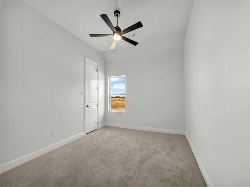 Carpeted empty room with ceiling fan and vaulted ceiling