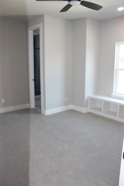 Empty room featuring carpet flooring and ceiling fan