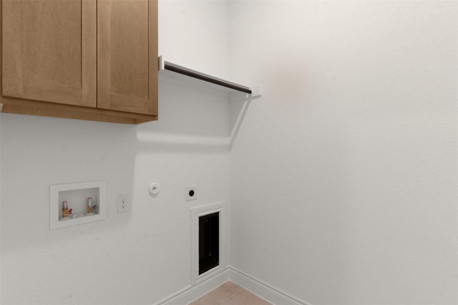 Laundry area featuring hookup for a gas dryer, washer hookup, cabinet space, electric dryer hookup, and light tile patterned floors