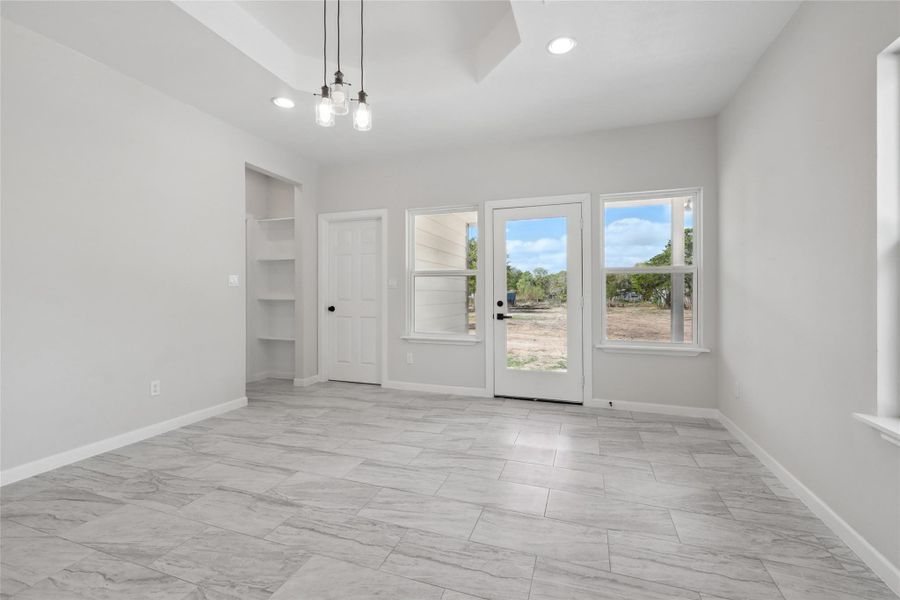 Spare room with light marble finish floors, a chandelier, recessed lighting, baseboards, and built in features Spare room with light marble finish floors, a chandelier, recessed lighting, baseboards, and built in features
