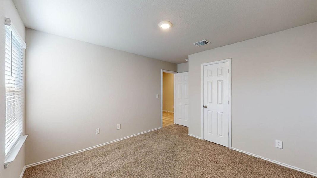Unfurnished bedroom with carpet flooring and multiple windows