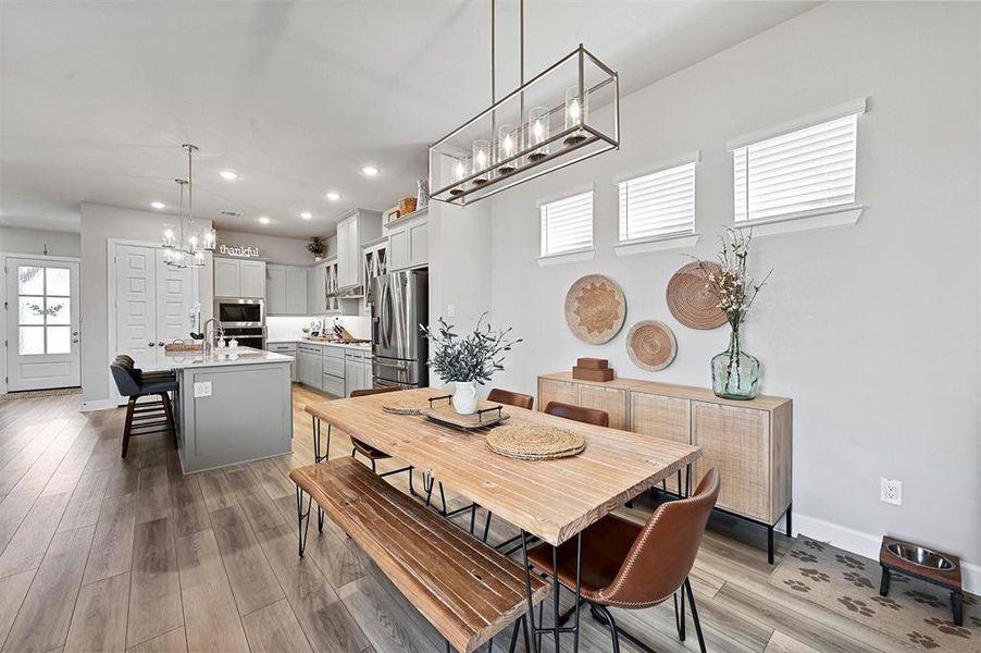 Dining space featuring a chandelier, recessed lighting, and light wood-type flooring Dining space featuring a chandelier, recessed lighting, and light wood-type flooring