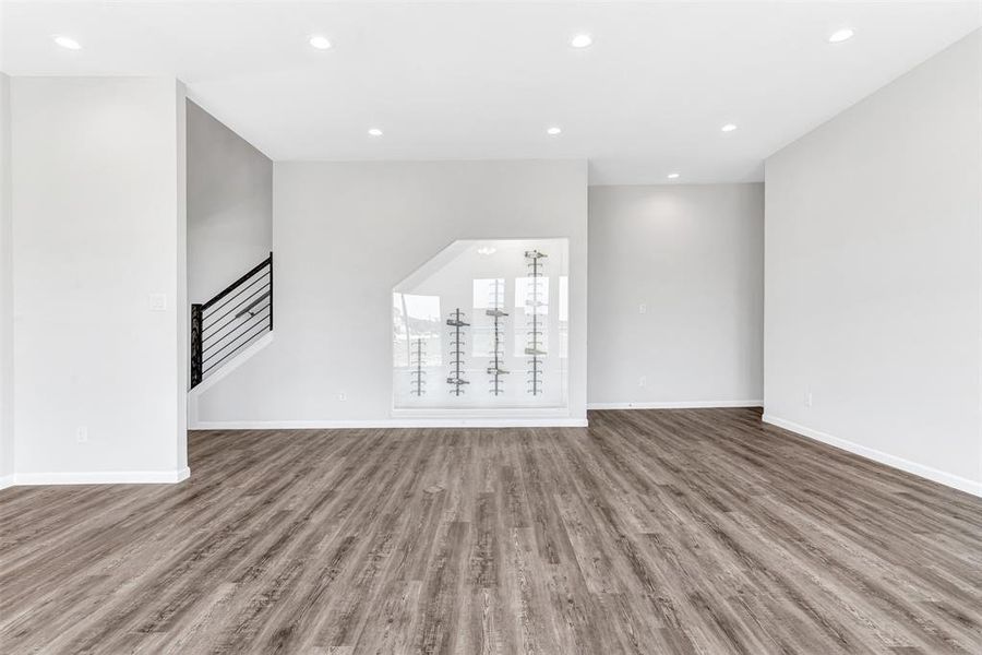 Unfurnished living room featuring hardwood / enclosed wine closet/ wood-style flooring