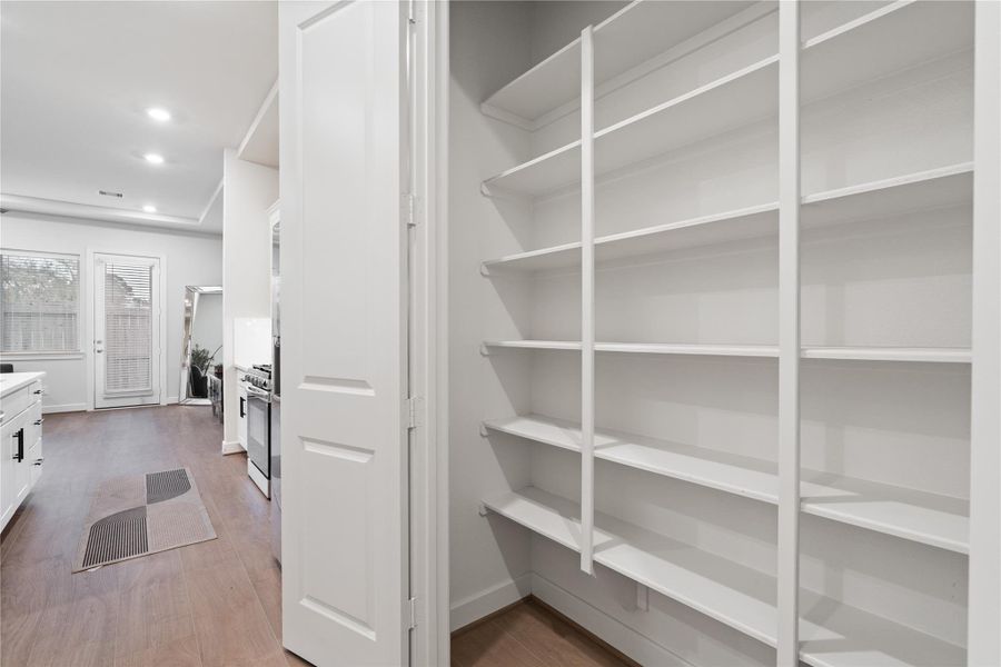 Reach in pantry with built in full height shelving, keeping dry goods and kitchen storage organized and out of sight.