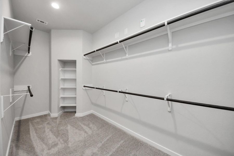 Walk-in closet that epitomizes luxury and practicality. This generously sized space features built-in shelving, offering abundant room for impeccable organization. High ceilings and recessed lighting create a bright and welcoming ambiance. Walk-in closet that epitomizes luxury and practicality. This generously sized space features built-in shelving, offering abundant room for impeccable organization. High ceilings and recessed lighting create a bright and welcoming ambiance.