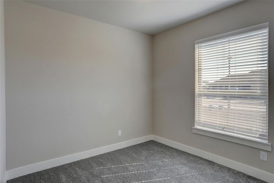 Carpeted spare room with baseboards