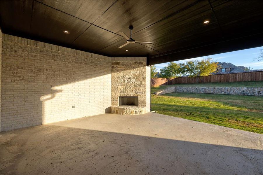 View of patio / terrace featuring an outdoor stone fireplace and ceiling fan