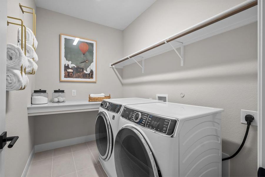 Laundry area featuring independent washer and dryer and light tile patterned floors