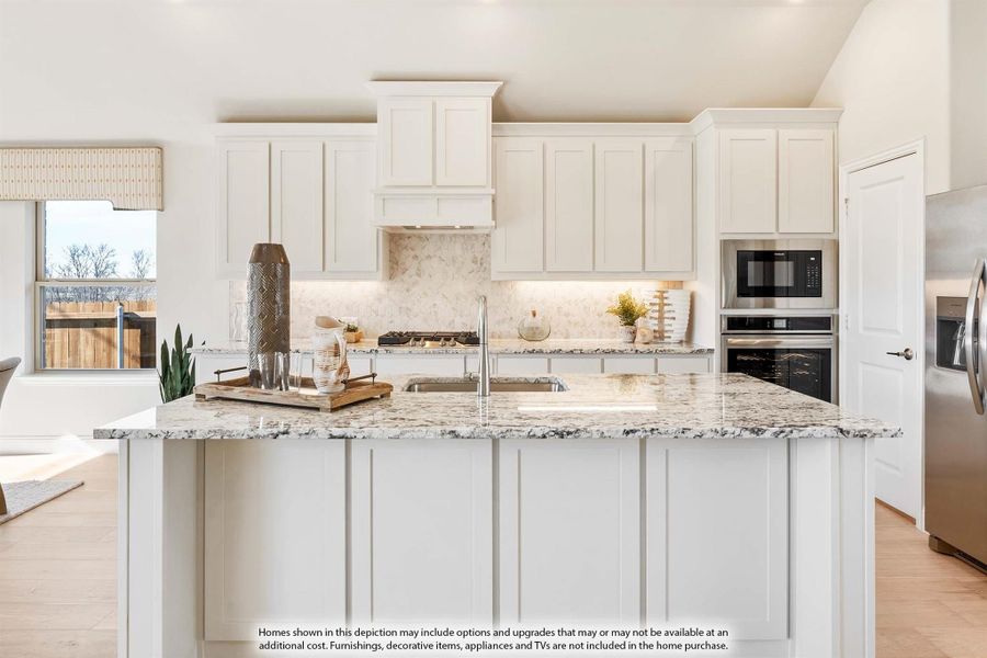 Kitchen with large island, granite countertops, white cabinets, stone backsplash, and stainless steel appliances Kitchen with large island, granite countertops, white cabinets, stone backsplash, and stainless steel appliances
