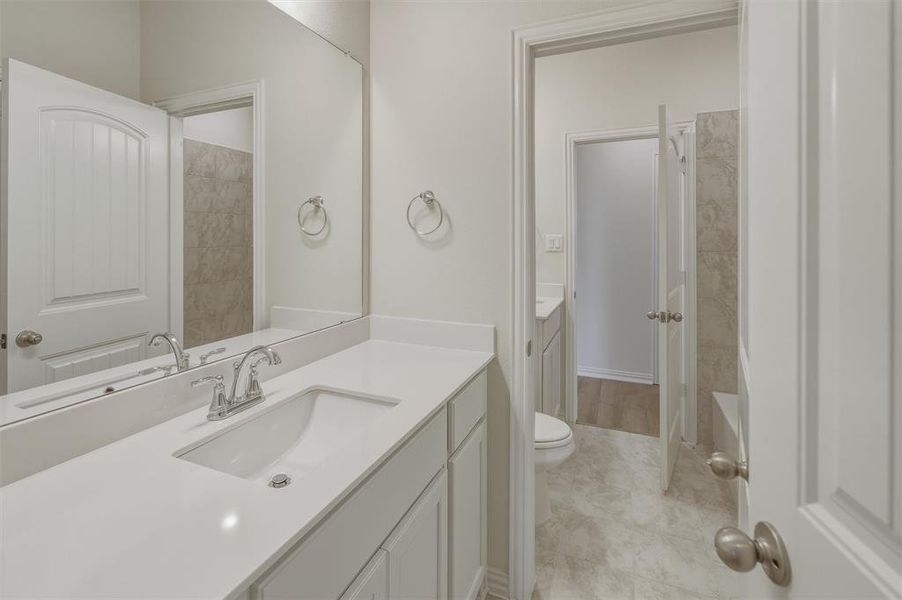 Double vanity with integrated sinks, chrome fixtures, and a full-width mirror