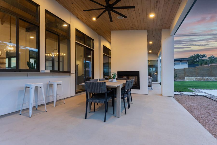 Expansive covered patio featuring a wood-finish ceiling, recessed lighting, and a built-in fireplace Expansive covered patio featuring a wood-finish ceiling, recessed lighting, and a built-in fireplace