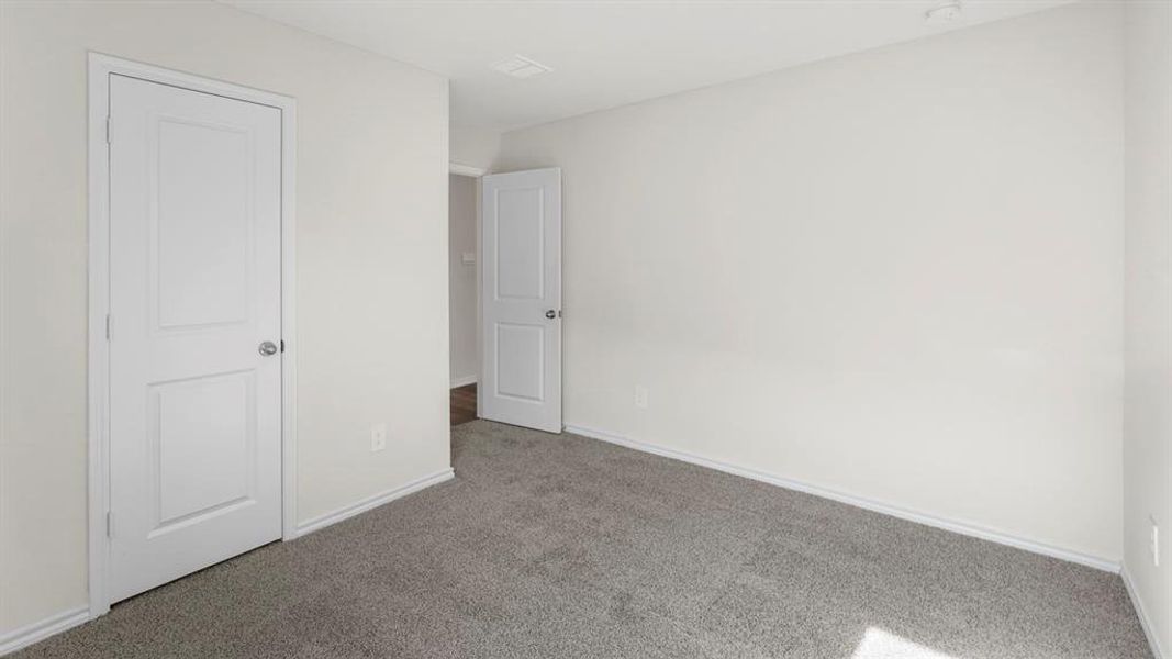 Gray carpet flooring with white baseboards and neutral wall paint