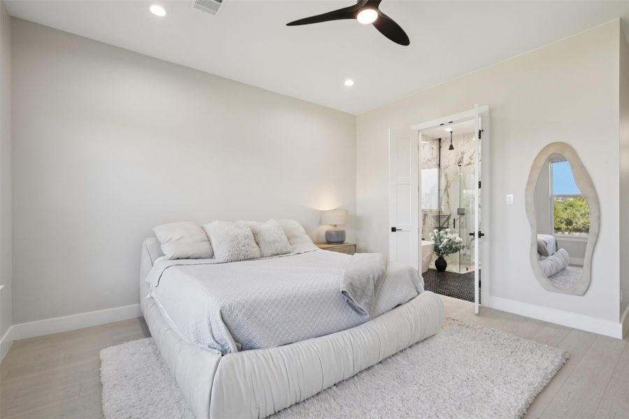 Bedroom featuring light wood-style floors, a ceiling fan, connected bathroom, and recessed lighting