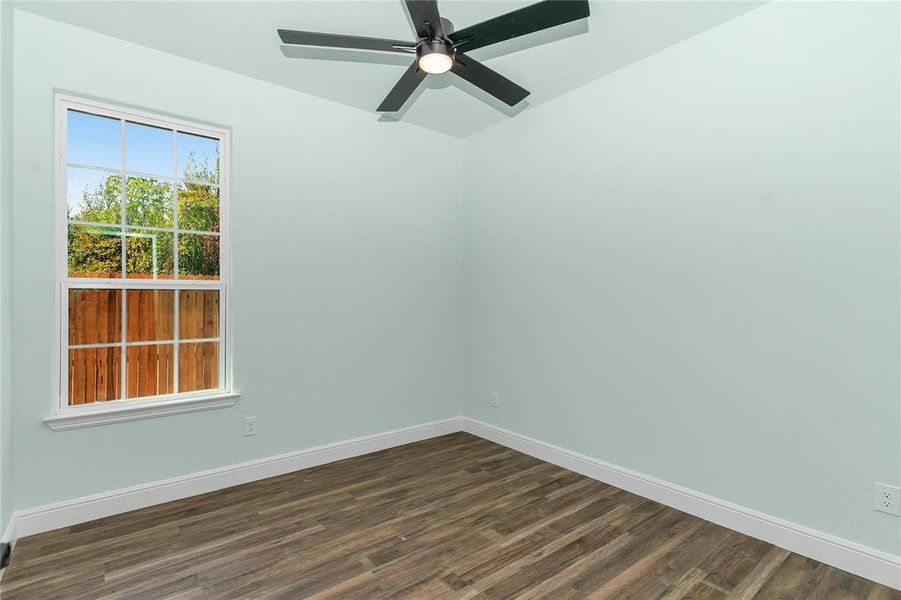 Unfurnished room with dark wood-style flooring and a ceiling fan