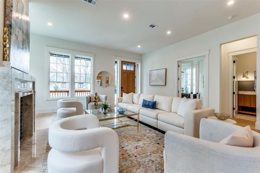 Living room featuring plenty of natural light and a high end fireplace