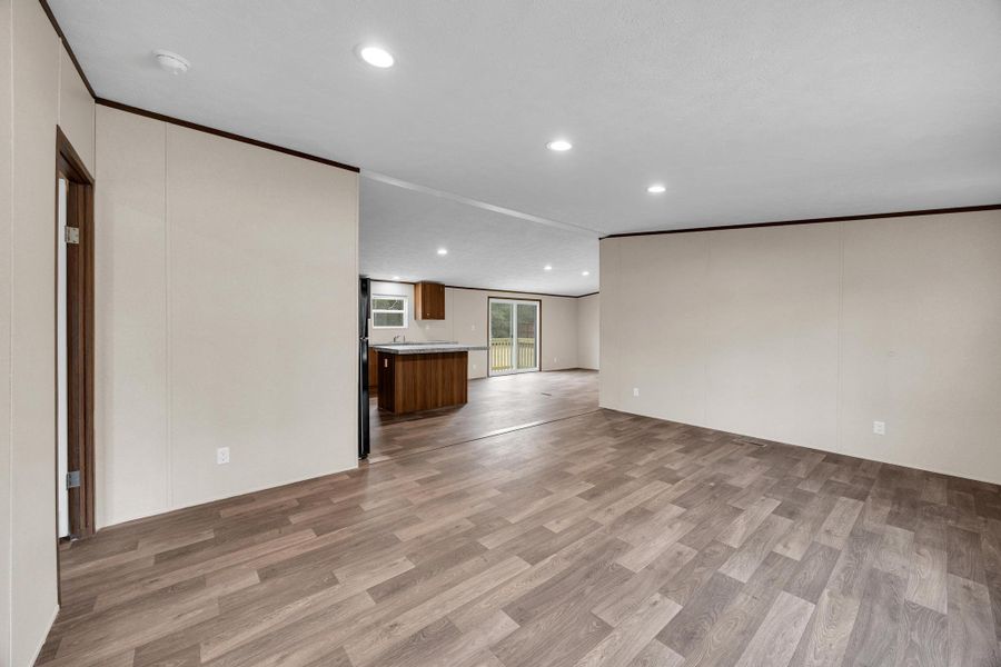Unfurnished living room with light wood-type flooring, recessed lighting, and crown molding