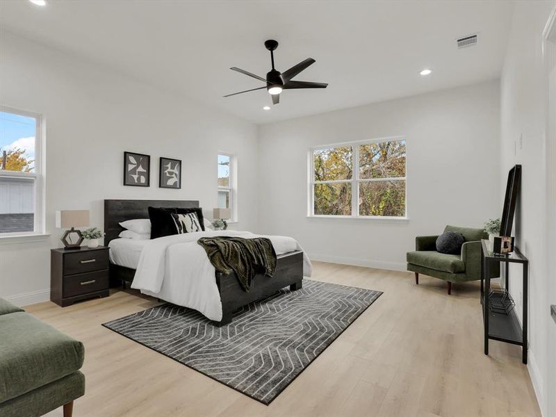 Bedroom with light hardwood / wood-style floors, multiple windows, and ceiling fan