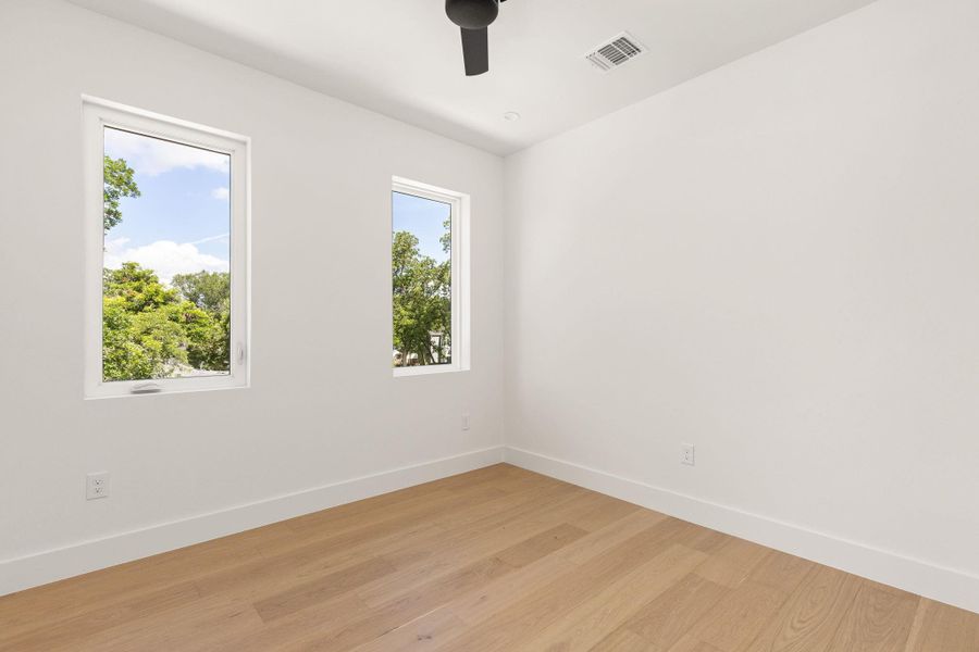 Hardwood floors and a high ceiling create an airy atmosphere in this well-lit room. Hardwood floors and a high ceiling create an airy atmosphere in this well-lit room.