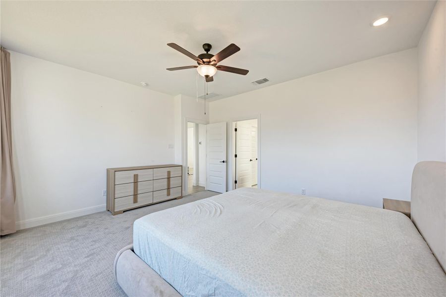 Spacious room featuring light-colored carpeting, recessed lighting, and a ceiling fan with integrated lighting