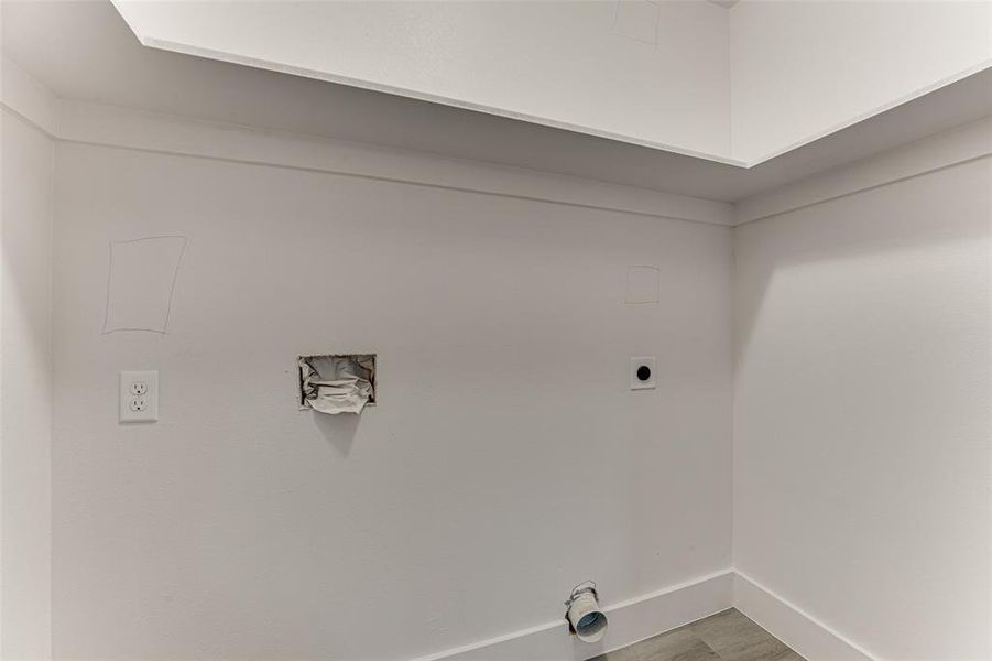 Laundry area featuring electric dryer hookup and wood-type flooring