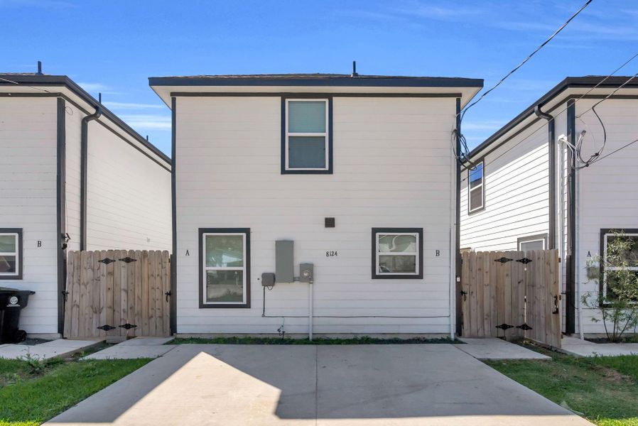 Modern duplex with a clean, white exterior and dark trim. Paved driveway and private fenced pathways leading to separate entrances. Suitable for buyers seeking a low-maintenance home. Modern duplex with a clean, white exterior and dark trim. Paved driveway and private fenced pathways leading to separate entrances. Suitable for buyers seeking a low-maintenance home.