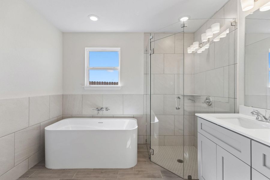 Bathroom featuring a freestanding tub and glass shower.