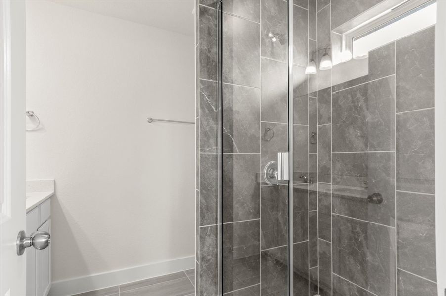 Bathroom featuring vanity, baseboards, and a stall shower