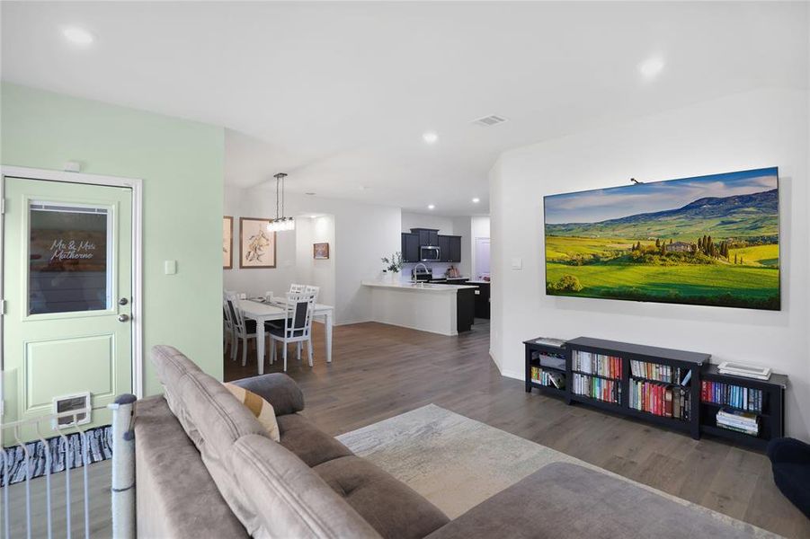 Living room with recessed lighting and dark wood-type flooring