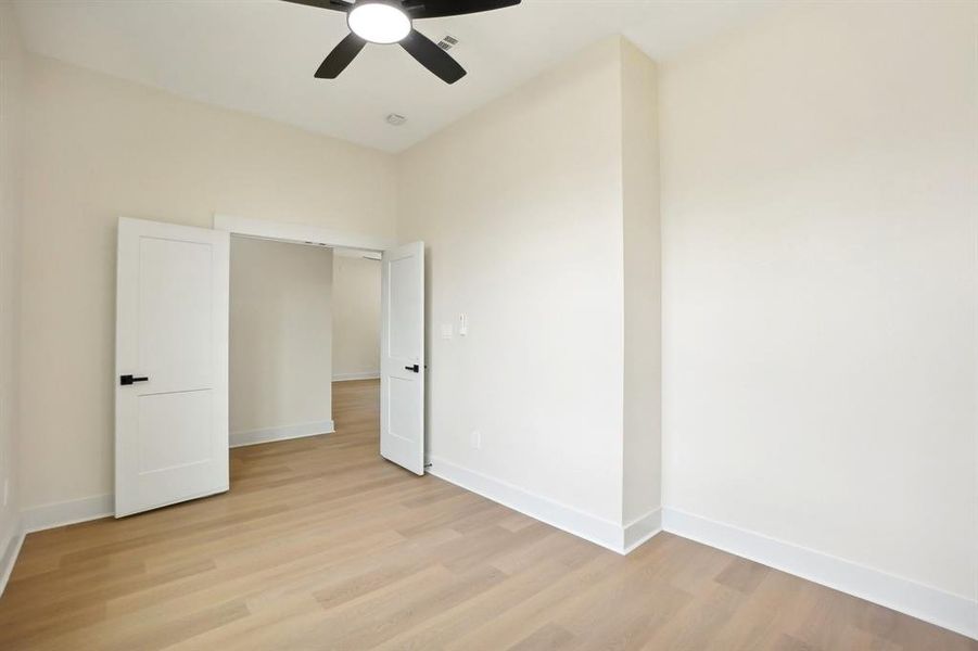 Unfurnished bedroom featuring light wood-type flooring, ceiling fan, and a closet