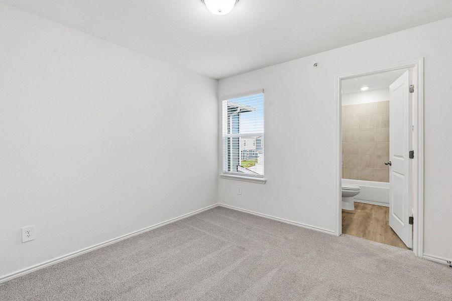 Neutral-toned carpeted room featuring a window with horizontal blinds and white trim Neutral-toned carpeted room featuring a window with horizontal blinds and white trim