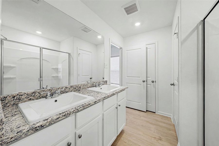 Granite counters and dual sinks define this bright, well-appointed bathroom.