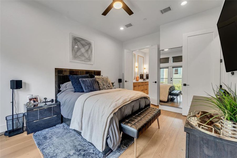 Bedroom with light wood-style flooring, recessed lighting, ceiling fan, and connected bathroom Bedroom with light wood-style flooring, recessed lighting, ceiling fan, and connected bathroom