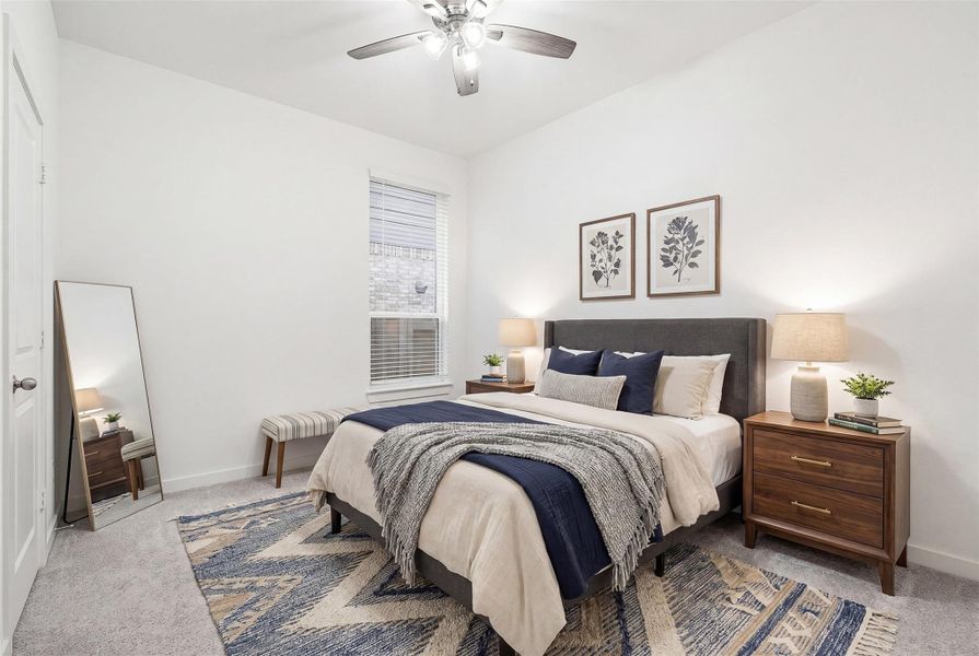 This first floor bedroom features soft carpeting, a ceiling fan, and a window with privacy blinds, offering a comfortable and inviting space filled with natural light. *virtually staged