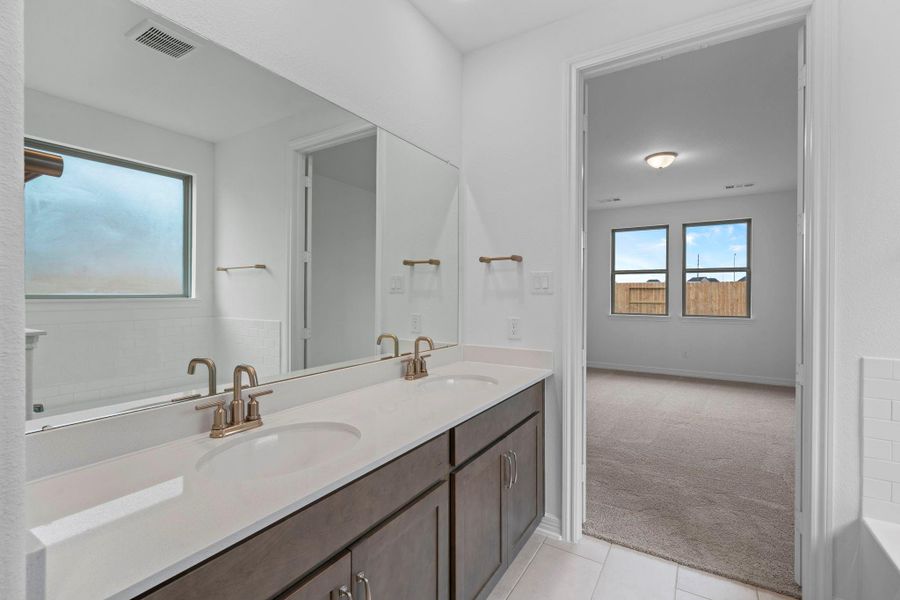 The en-suite bathroom offers a spa-like atmosphere with its elegant design, high end finishes, and tasteful lighting, creating a retreat within your own home.