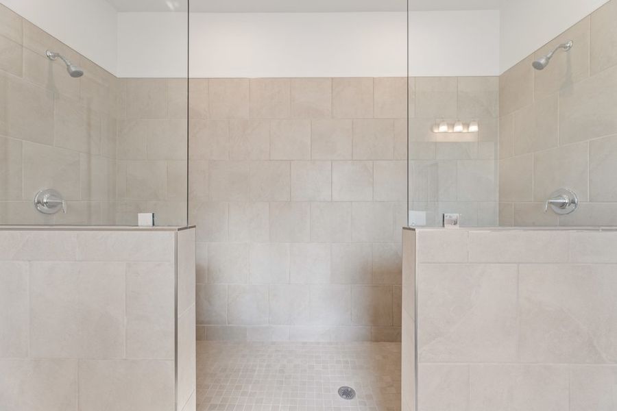 A bathroom with a shower unit and a toilet.