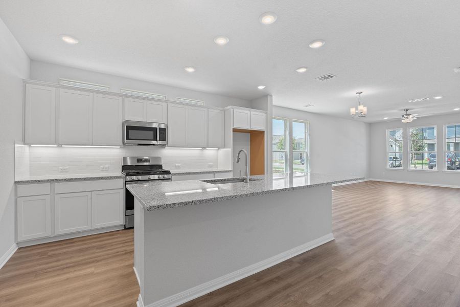 Kitchen featuring appliances with stainless steel finishes, white cabinets, light wood-style flooring, recessed lighting, and plenty of natural light