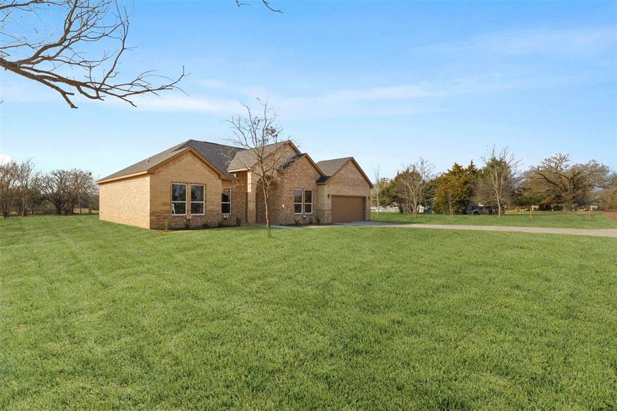 View of front of property featuring a garage and a front yard