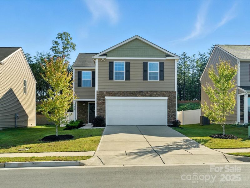eautiful two-story home featuring attractive stone accents, vinyl siding, and classic black shutters. Two-car garage with professional landscaping and well-maintained lawn create excellent curb appeal in desirable neighborhood setting.