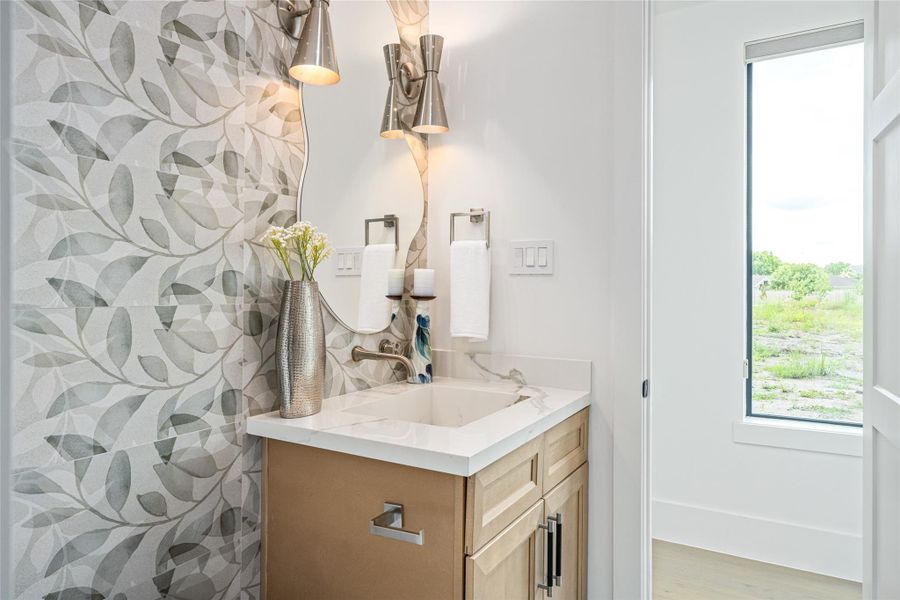 The onsite-designed porcelain wedge sink and spa-inspired walk-in shower with a built-in bench exude boutique hotel luxury The onsite-designed porcelain wedge sink and spa-inspired walk-in shower with a built-in bench exude boutique hotel luxury