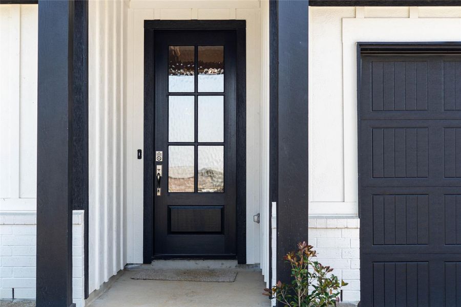 Exceptional curb appeal defines this residence. It features a bold matte black six-lite door with glass panes making it the focal point for this modern farmhouse entryway.
