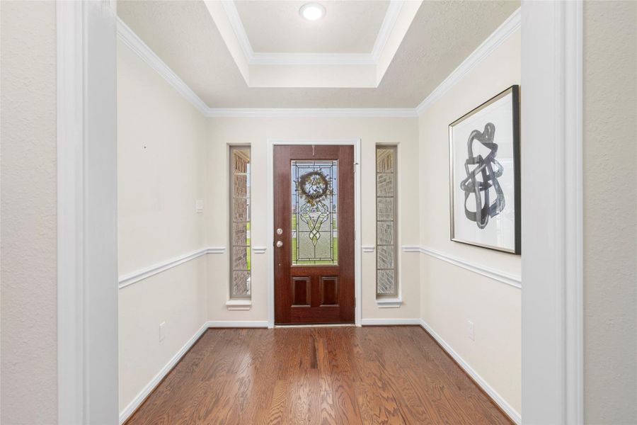 From the moment you cross the threshold, the tone is set. A soaring tray ceiling with crisp crown molding create an immediate sense of architectural refinement. The generous scale of the foyer offers the perfect canvas for statement art or coastal accents — a gracious welcome that leaves a lasting first impression. From the moment you cross the threshold, the tone is set. A soaring tray ceiling with crisp crown molding create an immediate sense of architectural refinement. The generous scale of the foyer offers the perfect canvas for statement art or coastal accents — a gracious welcome that leaves a lasting first impression.