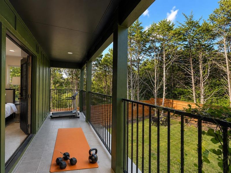Covered balcony featuring tile flooring and black metal railings